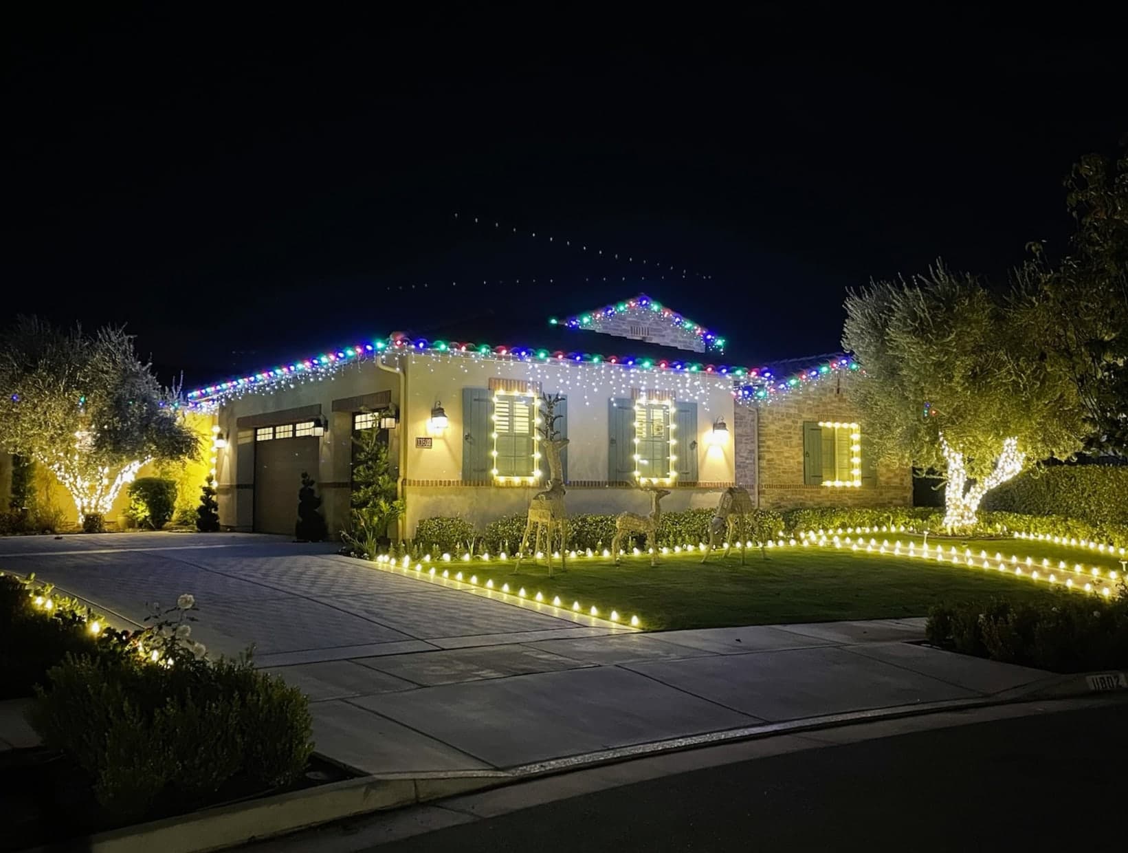 Multicolor Roofline with Warm White Trees & Pathway. Christmas light installation by Bright Idea Christmas Lights.
